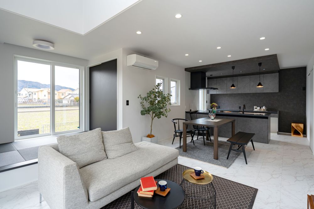 風景と採光を生かしつつ奥行きある空間を作り出したモノトーンインテリアの家